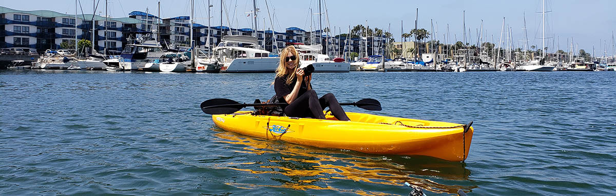 Carmen with camera on yellow kayak in marina - capturing nature photography
