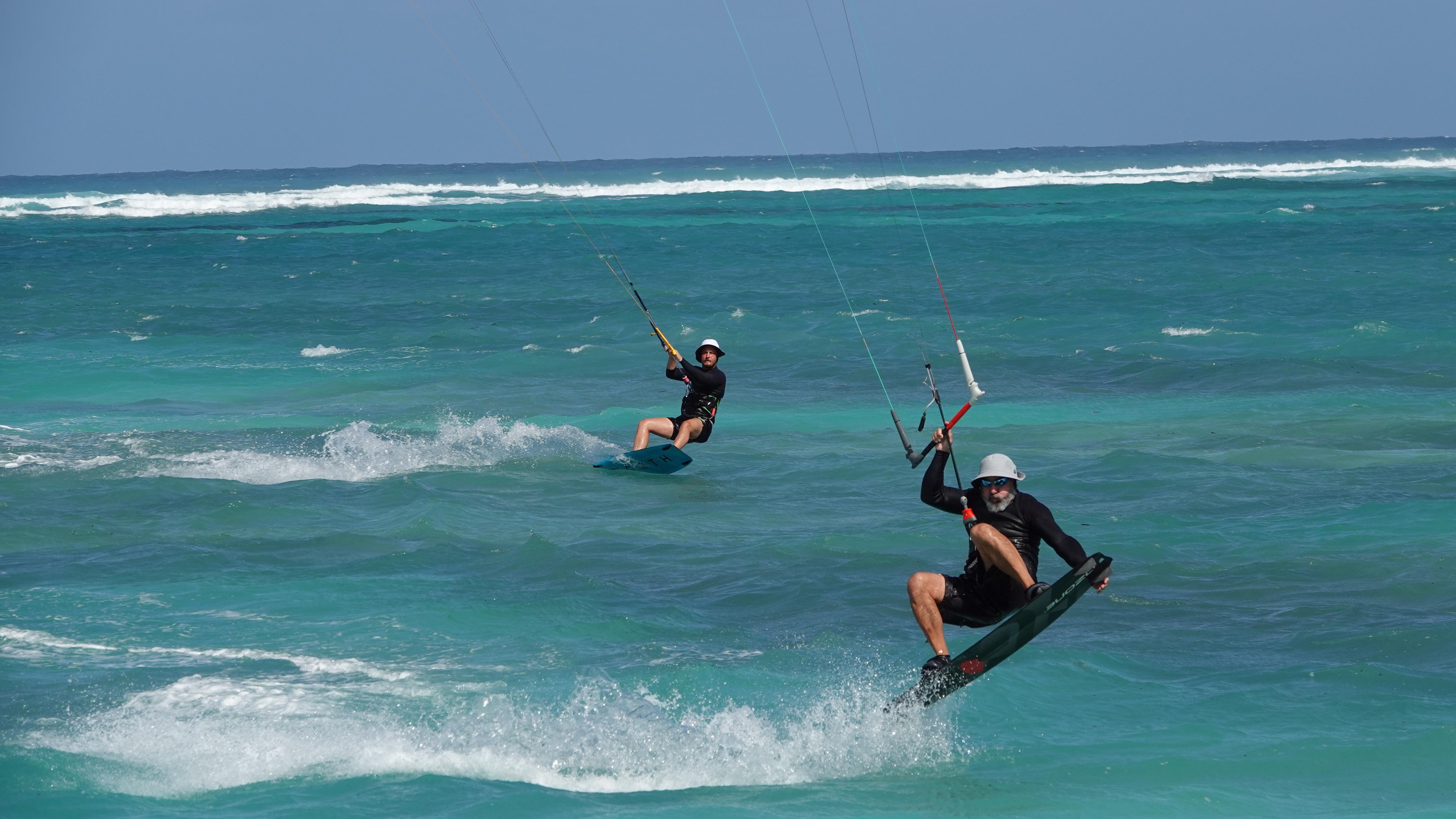 Two kiteboarders riding together in formation