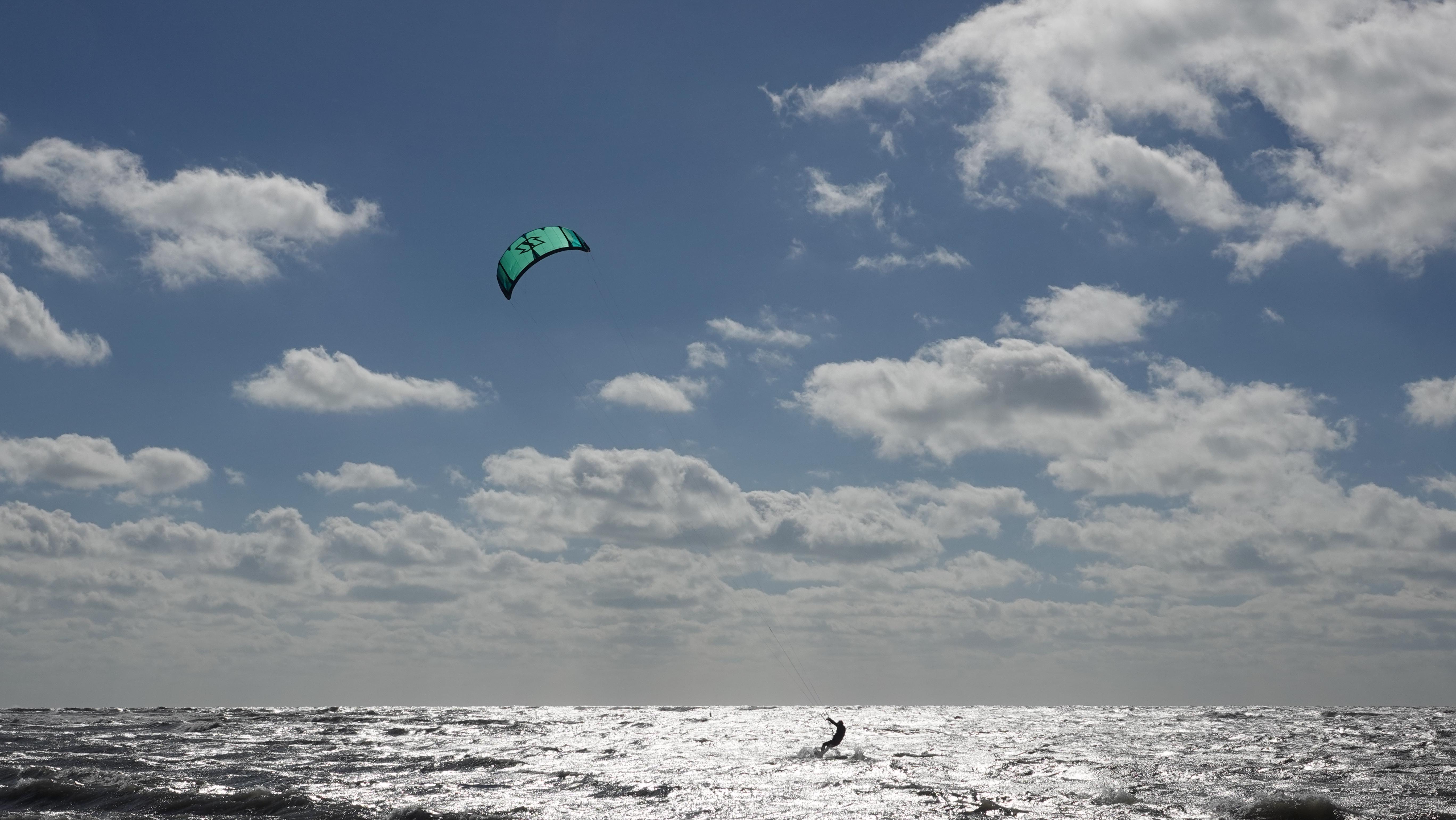 Wide scenic view with kite soaring against cloudy sky